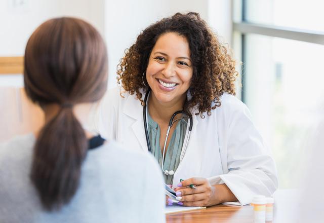 Doctor listening to patient and smiling